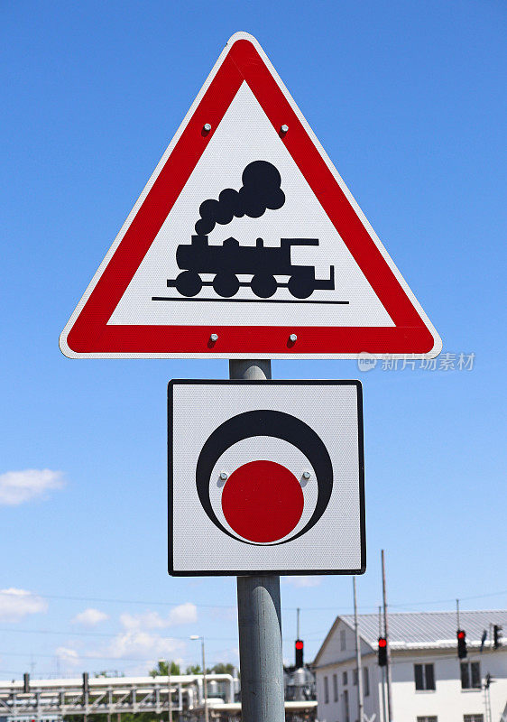 Train crossing road sign against blue sky